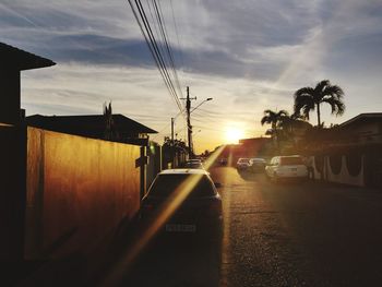 Cars on road against sky during sunset