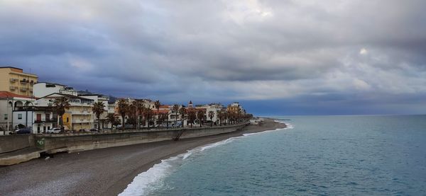 Buildings by sea against sky in city