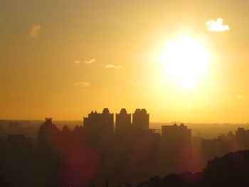 Silhouette buildings against sky during sunset