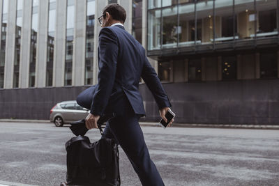 Rear view of man walking on street in city