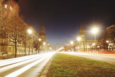 Light trails on road against sky at night