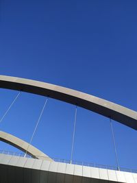 Low angle view of bridge against clear blue sky