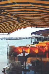 Empty restaurant table by sea against sky