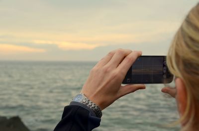 Cropped image of woman photographing through smart phone