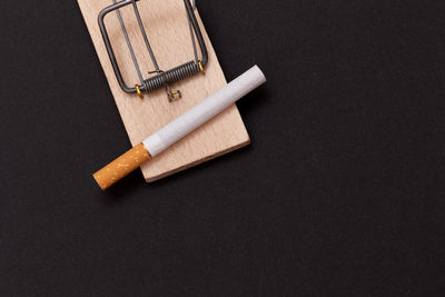 High angle view of cigarette on table against black background