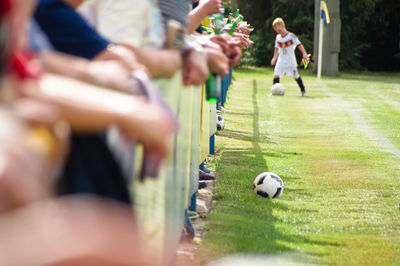 Midsection of people watching soccer match