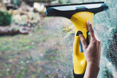 Close-up of hand holding yellow water