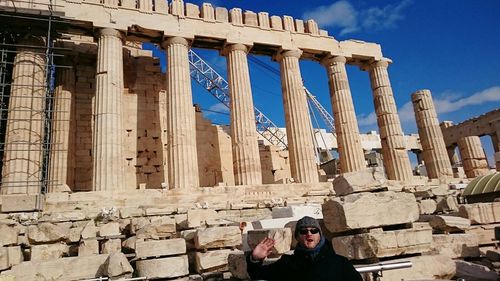 Man standing at acropolis of athens against sky