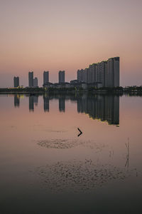 View of city buildings against sky during sunset