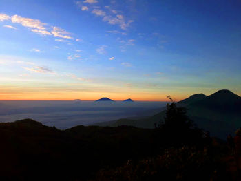 Scenic view of silhouette mountains against sky at sunset