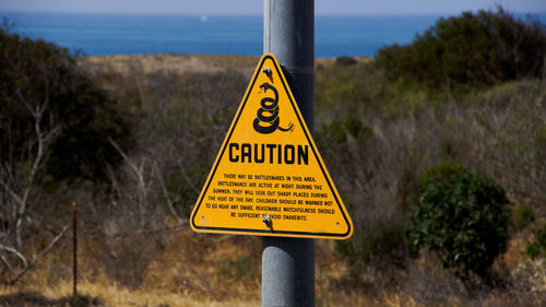 Close-up of warning sign on pole