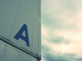 Low angle view of road sign against cloudy sky