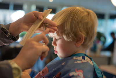 Cropped image of barber cutting boy hair