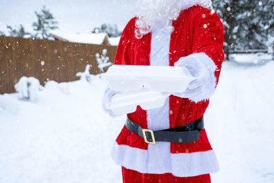 Rear view of woman holding snow