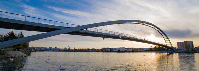 View of bridge over river against cloudy sky