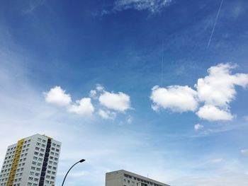 Low angle view of modern building against cloudy sky