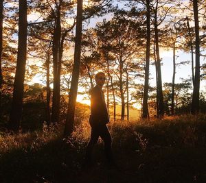 Man walking in forest at sunset