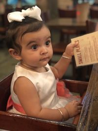 Portrait of cute baby girl sitting at home