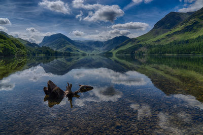 Scenic view of lake by mountains against sky