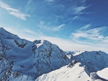 Scenic view of snowcapped mountains against blue sky