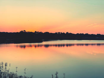 Scenic view of lake against romantic sky at sunset