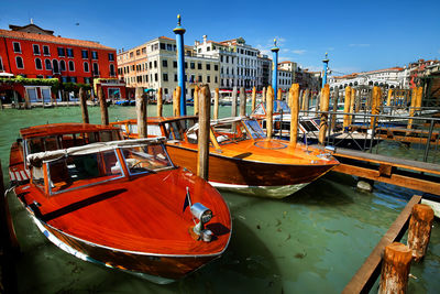 Motorboats moored at harbor on sunny day