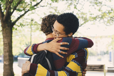 Male friends embracing each other in park