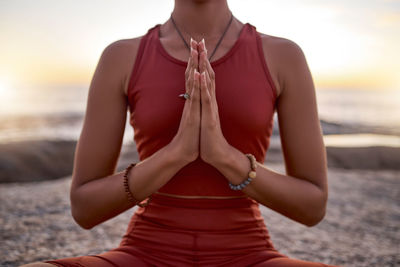 Midsection of woman exercising at beach