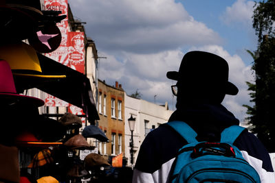 Rear view of man with bowler hat standing against sky