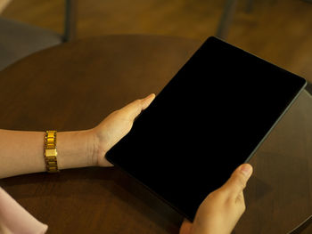 Midsection of woman reading book on table