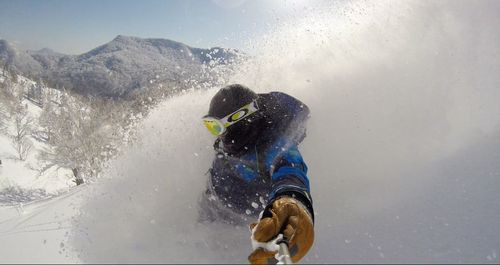 Person skiing on snowcapped mountains during winter