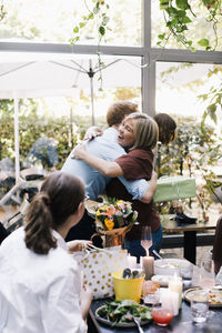 Happy parent embracing son during birthday party at restaurant