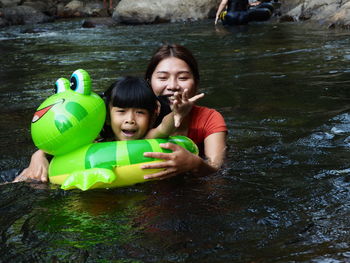 Portrait of happy mother and daughter in river