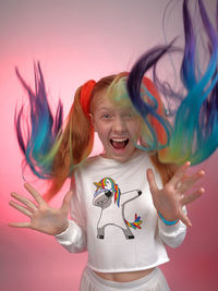 Portrait of a smiling girl against colored background