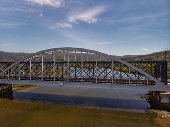 View of bridge over river against cloudy sky