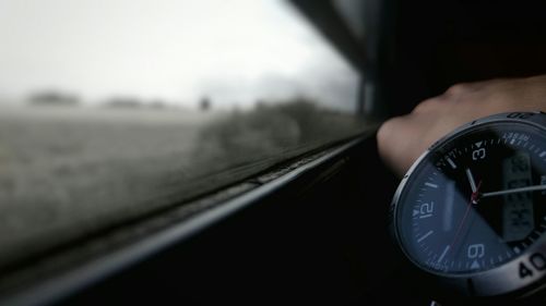 Close-up of hand on car windshield