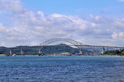 View of bridge over sea against cloudy sky