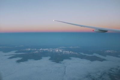 Airplane flying in sky at sunset