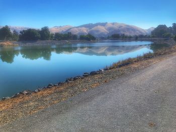 Scenic view of lake by mountains against sky