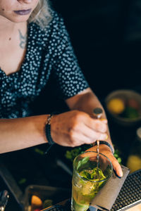 Waitress preparing a mojito cocktail in a bar.