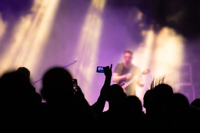 Silhouette people photographing at music concert