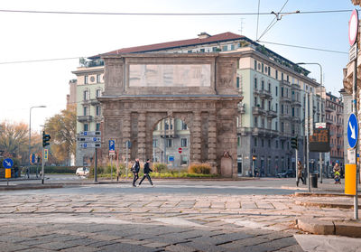 People walking on street amidst buildings in city