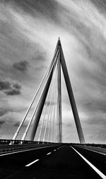 Bridge over river against cloudy sky