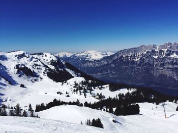 Scenic view of snow covered mountains against clear sky