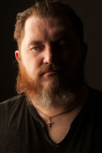 Close-up portrait of man against black background