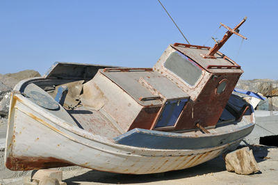 Abandoned boat moored against clear sky