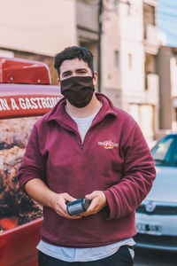 Man using mobile phone while standing on car