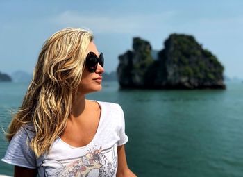 Woman wearing sunglasses against sea