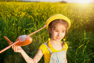 Portrait of girl playing with yellow flower