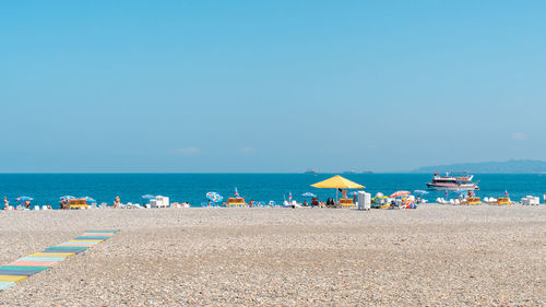 Scenic view of beach against clear blue sky